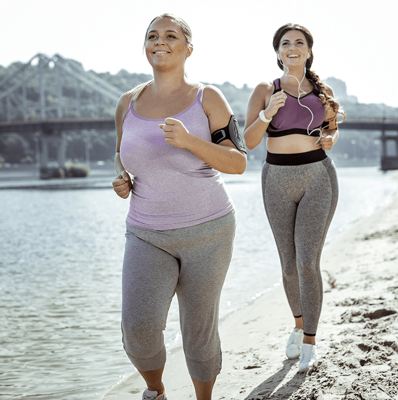 Two ladies running on the beach.